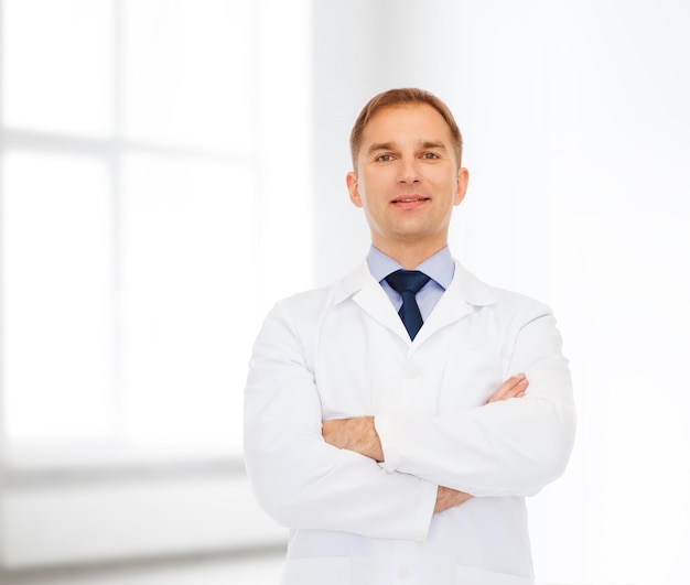 gesundheits-, berufs- und medizinkonzept - lächelnder männlicher arzt im weißen kittel über weißem raumhintergrund