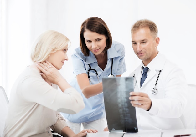 gesundheits-, medizin- und radiologiekonzept - ärzte mit patienten, die röntgenstrahlen betrachten