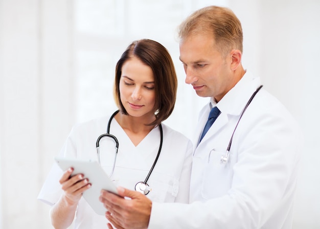 Gesundheits- und Medizin- und Technologiekonzept - zwei Ärzte betrachten Tablet-PC