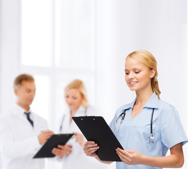 Gesundheits- und Medizinkonzept - lächelnde Ärztin oder Krankenschwester mit Stethoskop und Zwischenablage