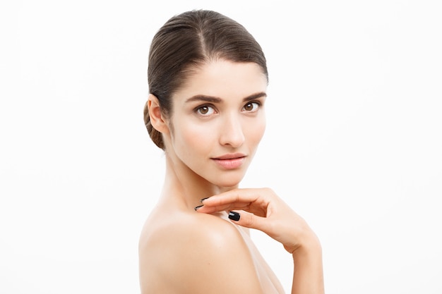 Gesundheits- und Spa-Konzept - attraktive junge und gesunde Frau mit nacktem Make-up auf weißer Wand.