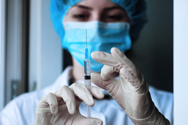 Gesundheitspersonal wählt den Impfstoff in eine Spritze