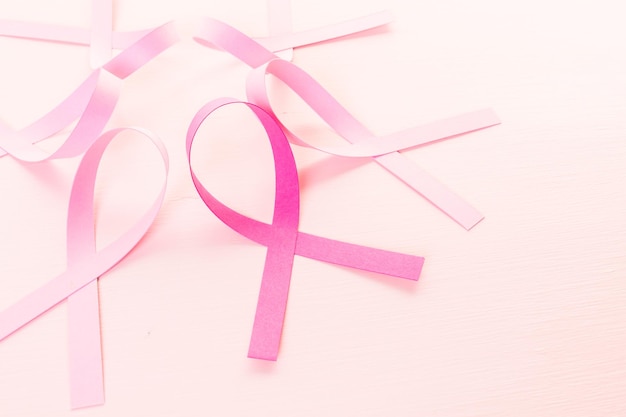Gesundheitssymbol der Frauen in rosa Schleife auf einem rosa Hintergrund.