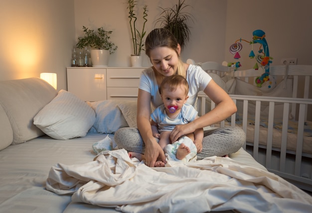 Getöntes Bild von Mutter, die Windeln zu ihrem Baby wechselt