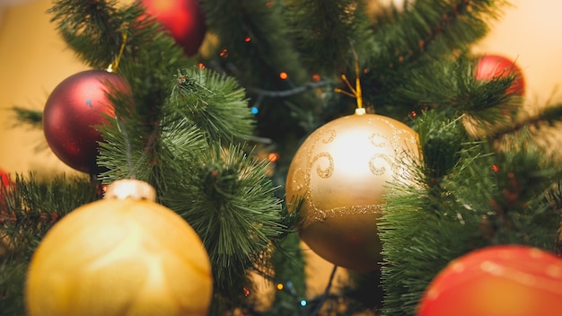 Getontes Bild der Nahaufnahme des roten und goldenen funkelnden Balls, der an Chrismtas Baum hängt. Perfekter abstrakter Hintergrund für Winterferien oder Feiern