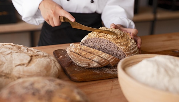 Getreidebäcker, der Brot schneidet