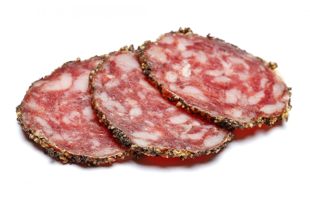 Getrocknete Bio-Salami-Wurst bedeckt mit Pfeffer auf weiß isoliert