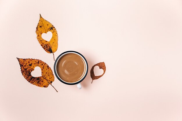 getrocknete Blätter mit Herz in der Mitte und Tasse Kaffee geschnitzt