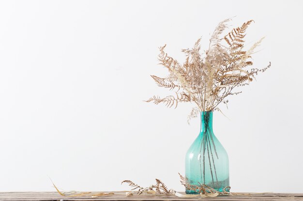 Getrocknete Blumen in Vase auf Holztisch auf weißem Hintergrund