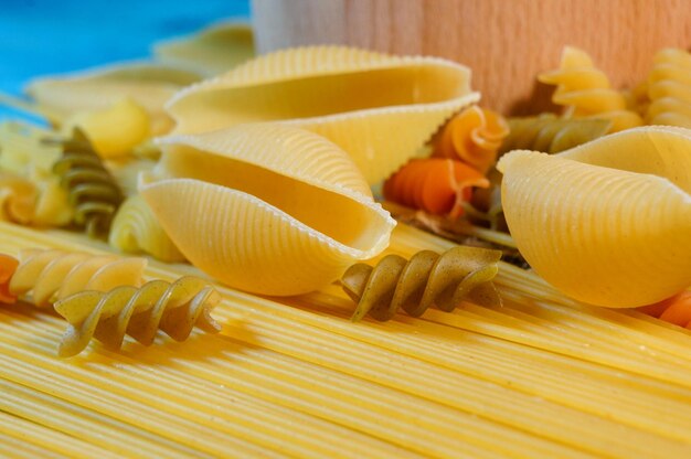 Getrocknete gemischte Pasta auf einem dunklen Holztisch Zusammensetzung der rohen italienischen Pasta Raw Pasta Hintergrund