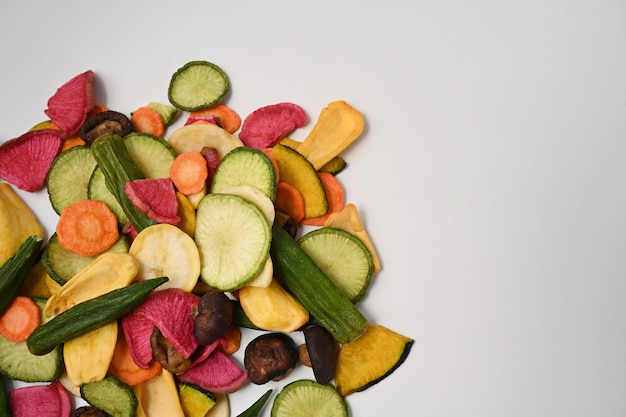 Getrocknete Gemüsechips mit Okra, Karotten, Kürbis, Rote Beete und Shiitake-Pilzen auf weißem Hintergrund.