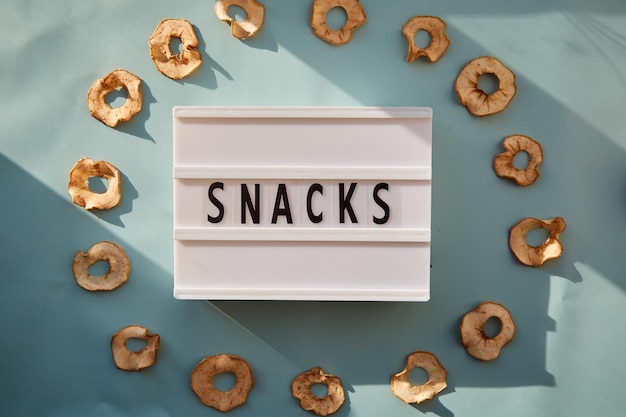 Getrocknete geschnittene Apfelchips und frische Äpfel gesunde alternative Snacks Textsnacks mit trendigen Schatten Richtiges Ernährungskonzept Draufsicht Kopierbereich