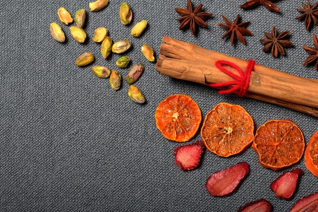 getrocknete Mandarinen und Erdbeeren in Stücke geschnitten Pistazien Anis und Zimtstäbchen