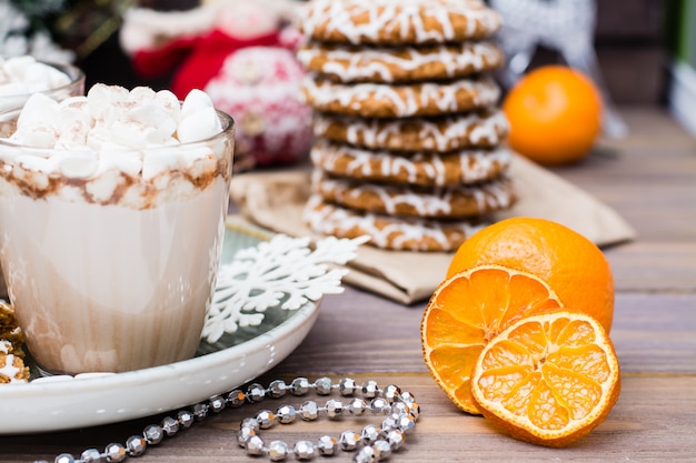 Getrocknete Mandarinenscheiben, heißer Kakao mit Eibischen und Weihnachtsplätzchen auf dem Tisch in den Weihnachtsdekorationen