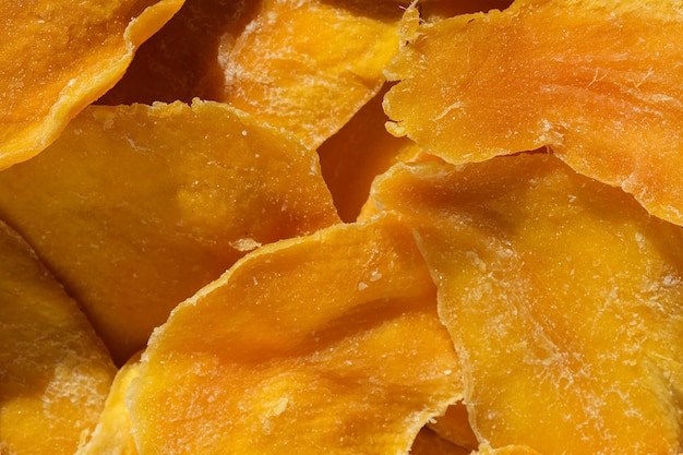 Getrocknete Mangoscheiben Nahaufnahme auf einem weißen Draufsicht Closeup Mango Chips Hintergrund Dehydrierte knusprige Fruchtscheiben Stücke Haufen von sonnengetrockneten gelben Früchten Gesunde Mahlzeit Draufsicht flach lag