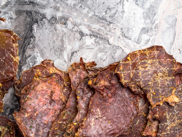 Foto getrocknete marmorierte fleischstücke, dehydrierte scheiben in gesalzenem kopierraum mit gewürzen