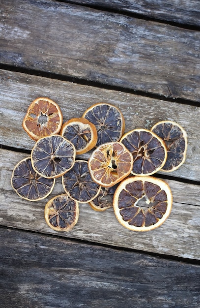 Foto getrocknete orangenscheiben auf verwitterten alten holzbrettern.