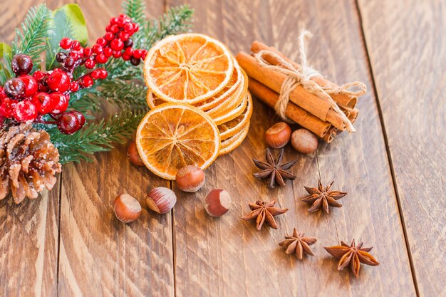 Getrocknete Orangenscheiben mit Gewürzen zum Kochen oder Backen auf altem rustikalem Holzhintergrund, gesundes Essen.