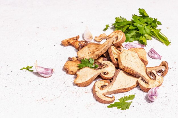 Getrocknete Pilze Boletus edulis (Penny Bun, Cep, Porcini) auf strukturiertem Gipshintergrund. Zutat für vegetarisches (veganes) gesundes Essen. Ein trendiges hartes Licht, dunkler Schatten, Kopierraum