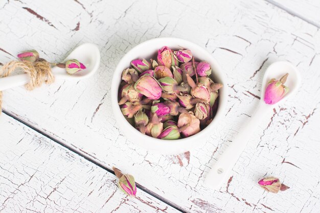 Getrocknete Rosebuds auf weißem hölzernem Hintergrund