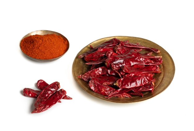 Getrocknete rote Chilischoten mit Chilipulver auf weißem Hintergrund