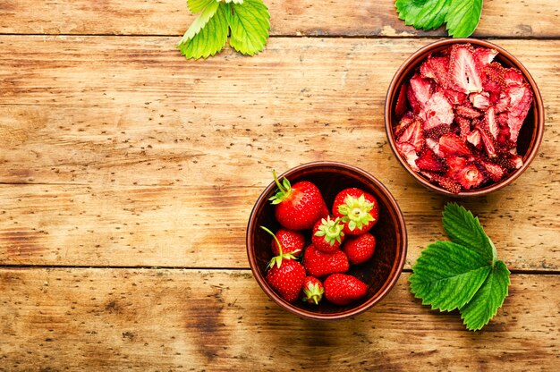 Getrocknete Sommerbeere, Fruchtdessert. Erdbeerchips, Beerensüße auf rustikalem Holzhintergrund. Platz kopieren