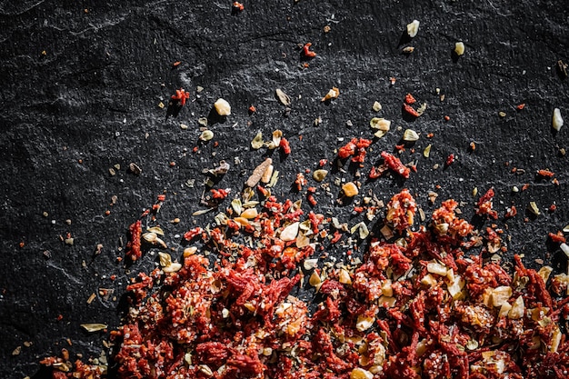 Foto getrocknete tomaten und chilischoten in der nähe auf luxuriösem steinhintergrund als flache lage trockenfuttergewürze und rezeptzutaten