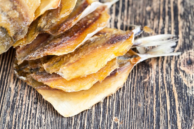 Getrocknete und geschlachtete kleine Fische auf einem Holztisch