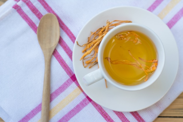 Getrockneter Cordyceps Militaris-Pilz mit Schale auf weißem Baumwollgewebe Hintergrund