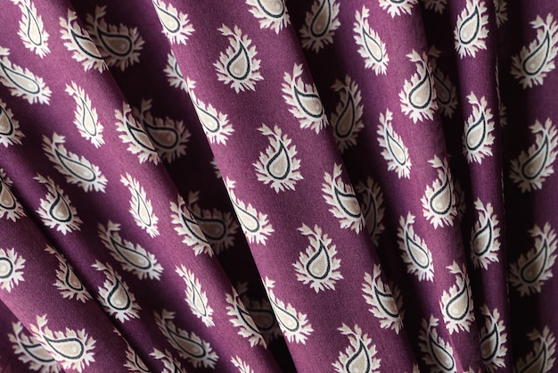 Gewellter violetter Stoff mit Ornament als Hintergrund violetter Stoff mit verstreutem Bild aus nächster Nähe