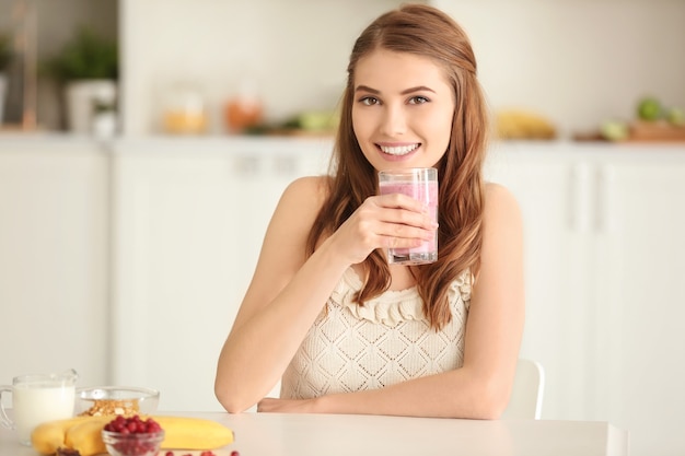 Gewichtsverlust Konzept. Schöne junge Frau, die gesunden köstlichen Smoothie in der Küche trinkt