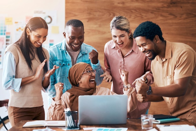 Foto gewinnende laptops und geschäftsleute bei der teamarbeit, erfolgsfeier im büro und online-nachrichten über bonusziele oder zielvorgaben. siegermitarbeiter oder diversity-frauen und -männer feiern mit faustpumpen am computer