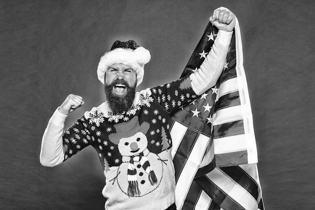 Gewinner gibt nie auf Glücklicher Gewinner hält amerikanische Flagge Bärtiger Mann macht Siegergeste Aufgeregter Weihnachtsmann schreit laut rosa Hintergrund Feiert Weihnachten und Neujahr Jackpot-Vintage-Filter
