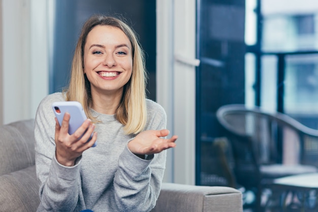 Gewinnerin schreit ja und freut sich über den Erfolg mit Blick auf das Handy