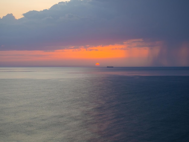 Gewitter auf See in der Abenddämmerung Die Schönheit der Sonnenaufgangswellen Meereslandschaft mit dramatisch bewölktem Himmel und aufgehender Sonne in Katar Die Aussicht vom Strand