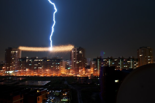 Gewitter in der Stadt, Blitzschlag in der Stromleitung zwischen dem Haus