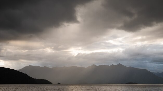 Gewitterwolken sammeln sich über dem See und der Bergkette Kepler Track Neuseeland