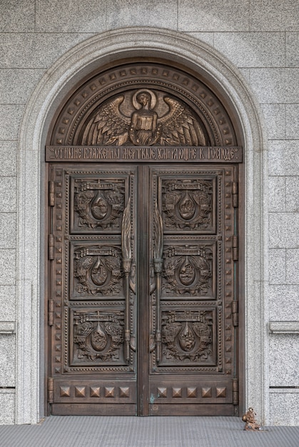 Gewölbte Holztür der Kirche mit Holzschnitzerei