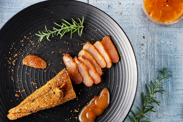 Foto gewürztes hähnchen mit scharfer soße und einem zweig rosmarin