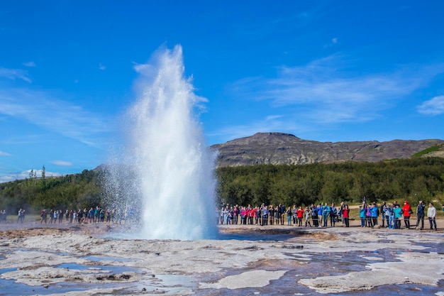 Geysir Strokkur com o sol no fundo do círculo dourado