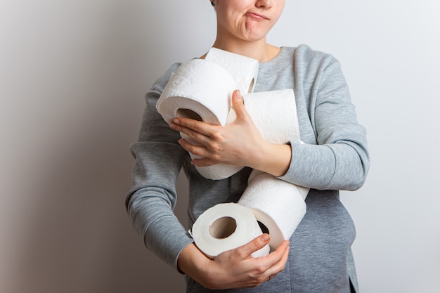 Gierige Frau hält einen Arm voll Toilettenpapier. Panik. Bestände während der Quarantänezeit der Coronavirus-Pandemie.