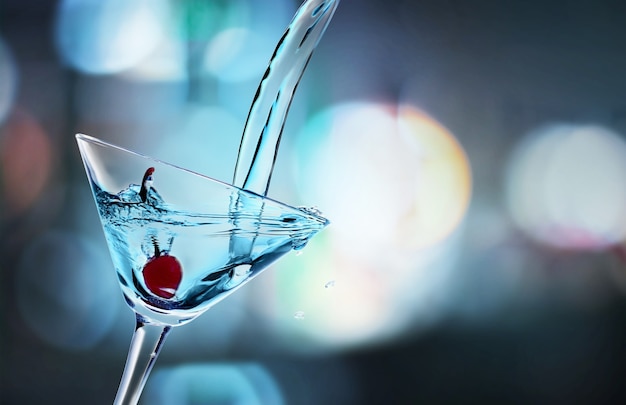 Gießen Martini-Cocktail in Glas auf unscharfem Hintergrund