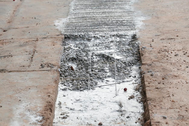 Gießen Sie Beton auf die Rohrleitung in einer ländlichen Dorfstraße.