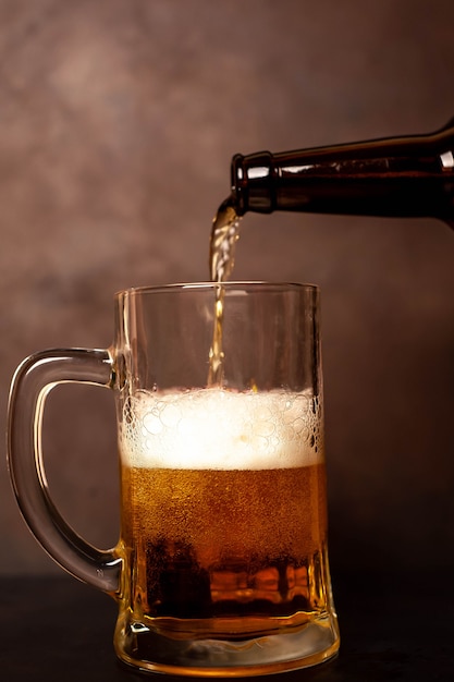 gießt Bier in ein Glas auf einem alten Stein