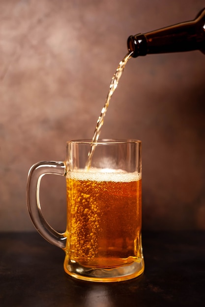 gießt Bier in ein Glas auf einem alten Stein