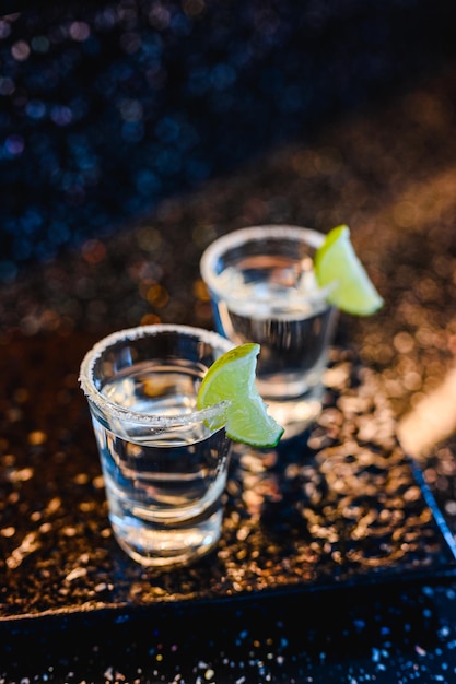 Gim ou vodka com limão. Dois copos com um álcool de coquetel com limões na superfície azul preta. Vodka, coquetel, álcool, bebida, restaurante, conceito de relaxamento.