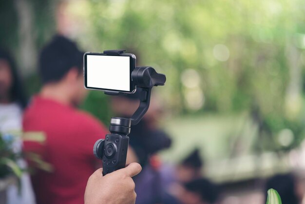 Gimbal in der Hand mit Smartphone-Videoaufnahme