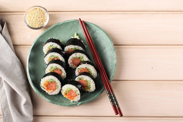 Gimbap de rolo coreano (kimbob ou kimbap) feito de arroz branco cozido no vapor (bap) e vários outros ingredientes, como kyuri, cenoura, salsicha, pau de caranguejo ou kimchi e embrulhado com lavadora de algas marinhas