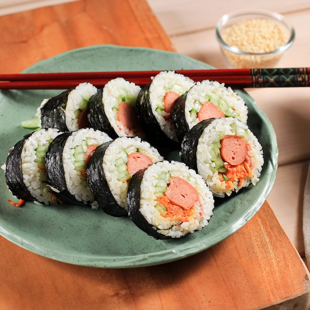 Gimbap de rolo coreano (kimbob ou kimbap) feito de arroz branco cozido no vapor (bap) e vários outros ingredientes, como kyuri, cenoura, salsicha, pau de caranguejo ou kimchi e embrulhado com lavadora de algas marinhas