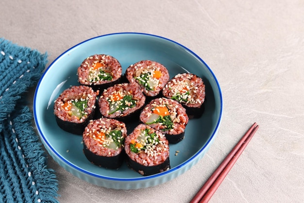 Gimbap oder Kimbap ist ein koreanisches Essen aus gedämpftem rotem Reis und verschiedenen anderen Zutaten